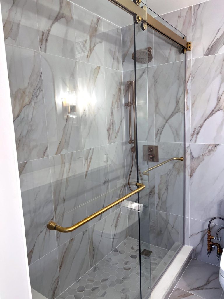 A white marble and gold hardware shower